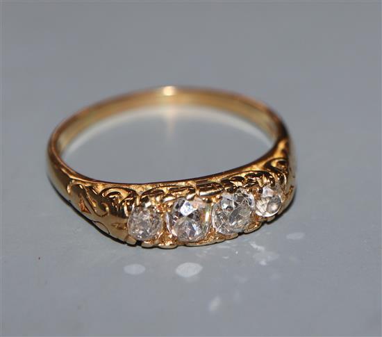 A modern Victorian style 18ct gold and graduated four stone diamond half hoop ring, size T.